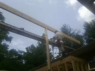 Carpenter setting a ridge beam over a new addition frame — Ice Dam Removal by Roofing Brothers in Salineville