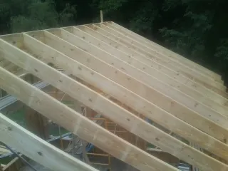 New roof rafters set over an addition before sheathing in Salineville