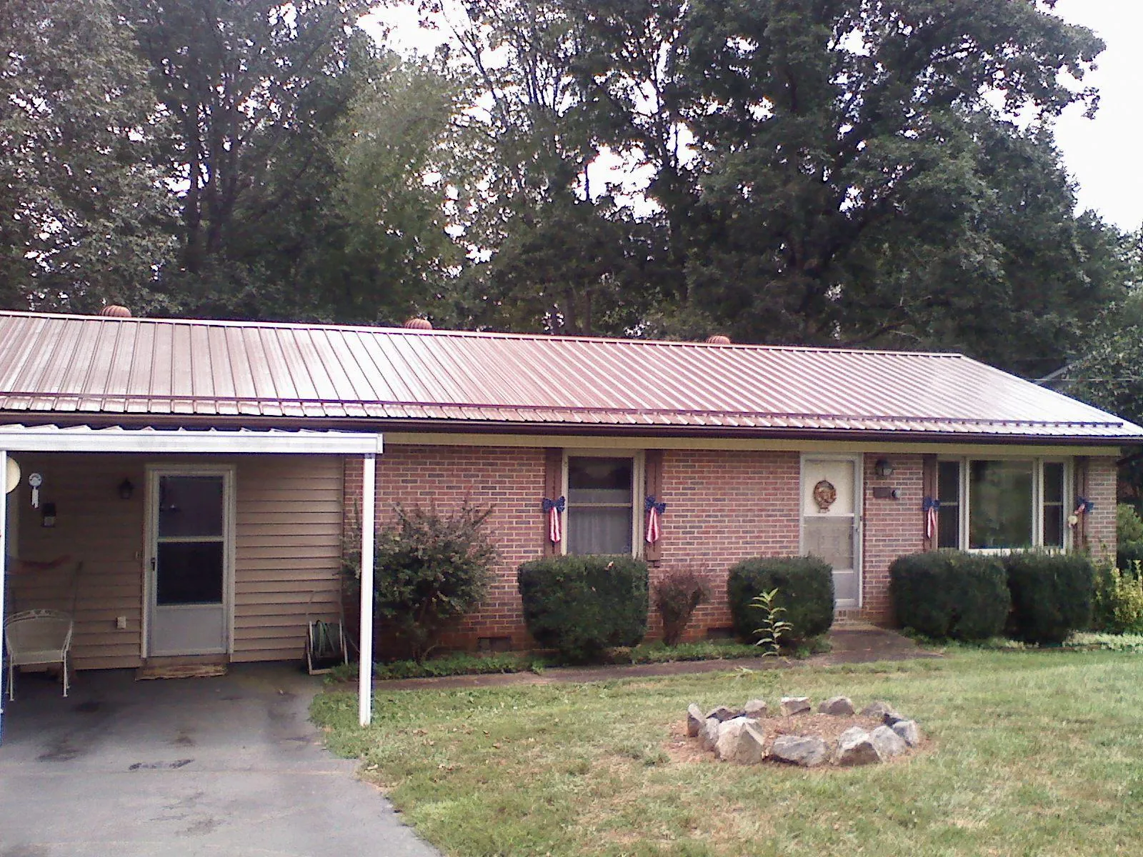 Bronze metal roof and carport on a brick ranch home — Roof Repair work by our crew in Salineville